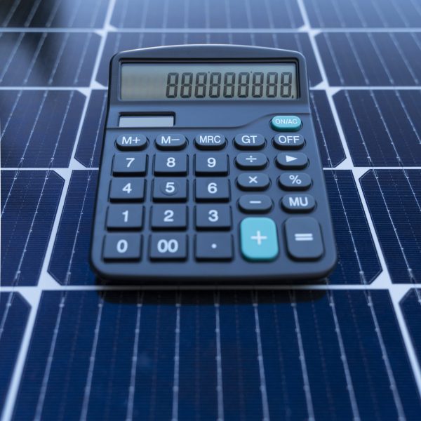 ile kosztuje 10 paneli fotowoltaicznych? - kalkulator leżący na panelach