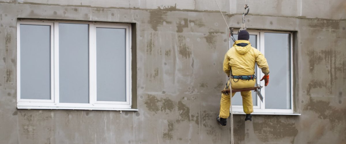 mycie elewacji częstochowa - pracownik myjący elewacje na zawieszeniu